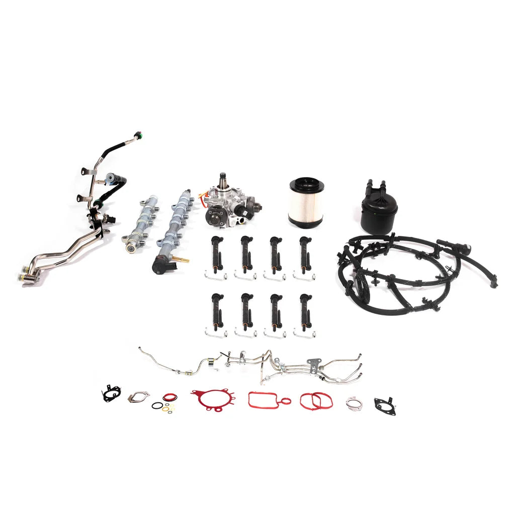 A complete automotive engine gasket kit laid out on a clean white background, containing various metal pipes, a camshaft, spark plugs, gaskets, seals, and wiring harnesses.